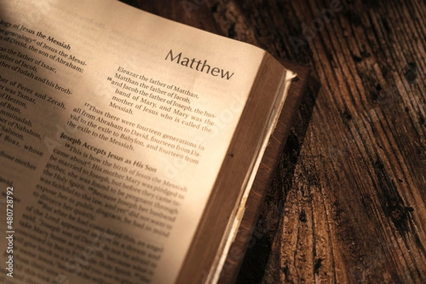 Fototapeta open bible on wooden table, chapter Matthew. contrast atmosphere