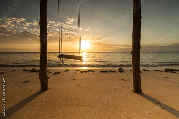 Fototapeta Beautiful swing during sunrise with colourful clouds in background, Zanzibar, Tanzania..