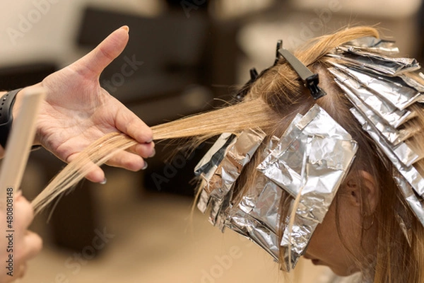 Obraz close-up. a hairdresser selects strands of hair for dyeing air touch