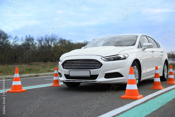Fototapeta Modern car on test track with traffic cones. Driving school
