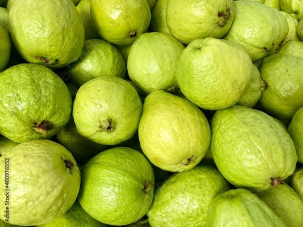 Fototapeta Close-up photo of guavas in market. Fruits background. Texture green guava. 