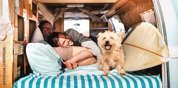 Fototapeta Hipster couple with cute pet traveling together on vintage rv campervan - Wanderlust and life inspiration concept with hippie lovers on mini van adventure trip - Bright warm filter with focus on dog