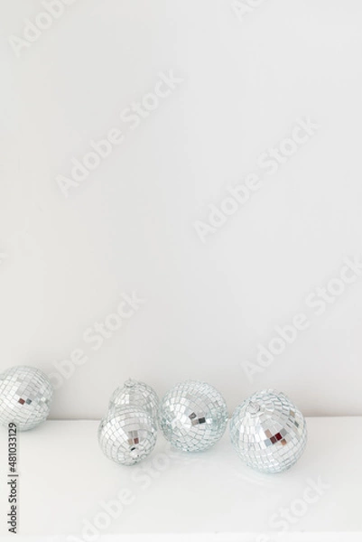 Fototapeta Disco mirror ball in the interior. Mirror disco ball on a white background. Minimalistic home decor. 