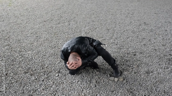 Fototapeta Bald man fell and holds his head after attack. 