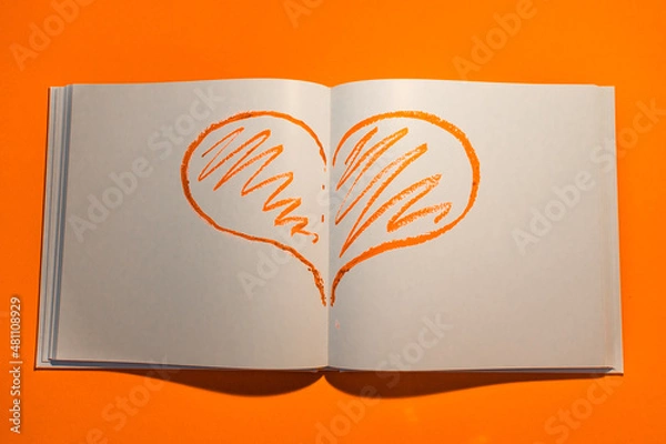 Fototapeta Drawn heart in a notebook on a yellow background. Happy Valentine's Day. High quality photo