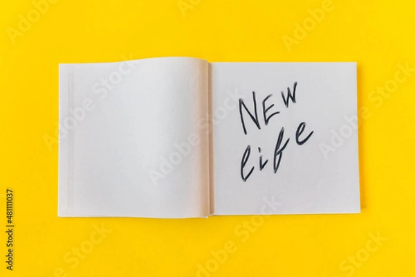 Fototapeta New life. Notepad with blank pages on a yellow background.High quality photo
