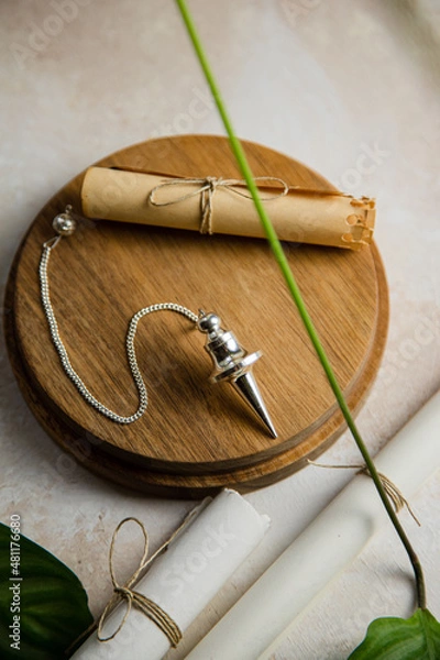 Obraz Silver divination pendulum on a wooden board
