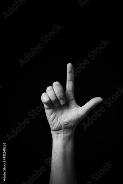 Fototapeta B+W image of hand demonstrating Chinese sign language letter L isolated against black background