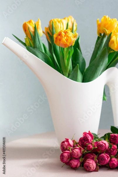 Fototapeta bunch of yellow tulips in a white bailer and pink roses, gardening or holiday concept, copy space