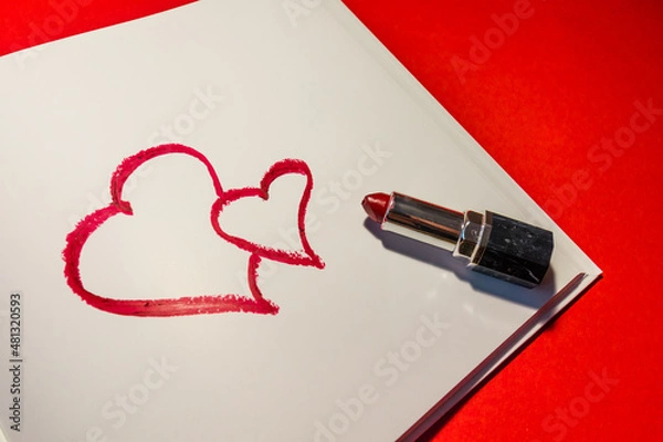 Obraz Two hearts are drawn with red lipstick in a notebook on a red background. Love message for Valentine's Day. High quality photo
