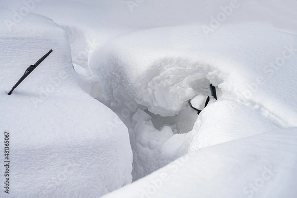 Fototapeta car covered with snow after a heavy snow storm.Vehicles are covered with snow during a heavy snowfall.