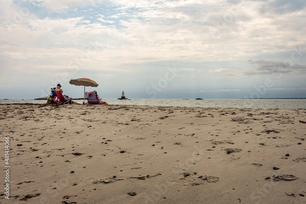 Fototapeta Family beach picnic with umbrellas on a cloudy day near Newport, Rhode Island