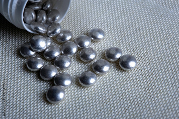 Obraz silver pills with a jar on a napkin