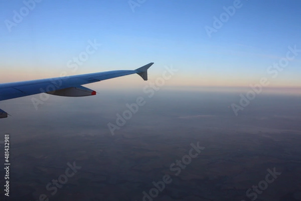 Fototapeta Sunset sky on airplane, plane window, over Europe in Friday evening flight for relax in holiday