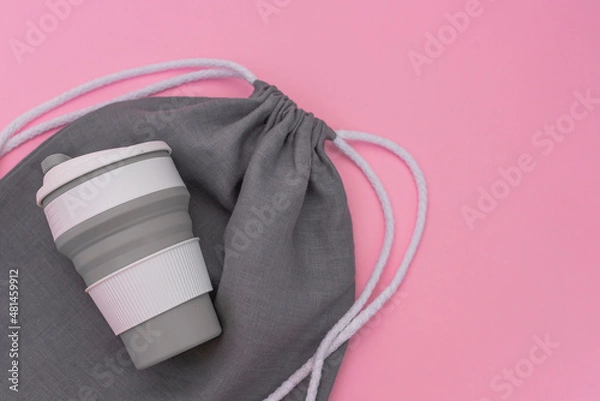 Fototapeta Trendy environmental friendly reusable cup. Grey shopping mesh bag. Concept of conscious consumption.