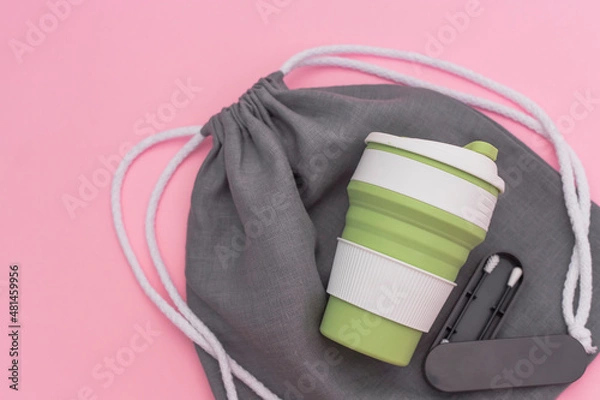 Fototapeta Trendy environmental friendly reusable cup. Reusable silicone ear stick. Grey shopping mesh bag. Concept of conscious consumption. Alternatives to disposables.