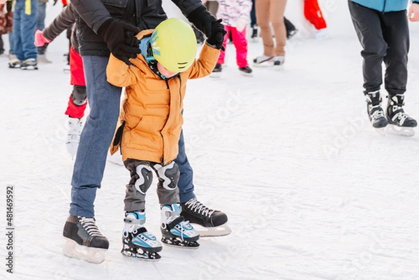 Fototapeta Soft,Selective focus.Funny moment fell on the ice skating rink. Activity, Adult, Child, Childhood, Daughter. Mom with baby boy 3-5 years old, learn train, ride winter city rink, ice skating.
