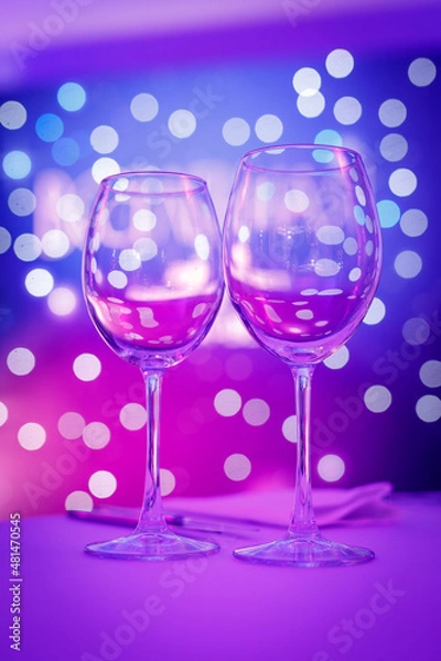 Fototapeta Empty wine glass with purple bokeh.