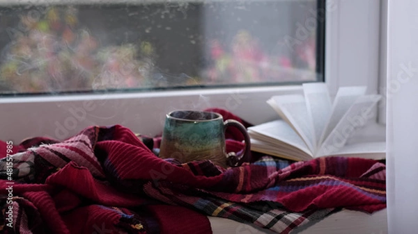 Fototapeta Steaming coffee cup on a rainy day window background. cozy atmosphere, in cold weather. Rainy Day Mood. warming home atmosphere