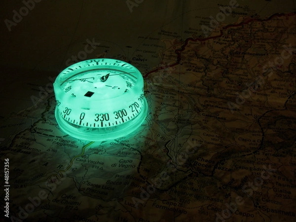 Obraz Glowing compass on a map