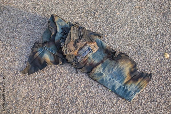 Fototapeta Burnt pants jeans trash lie on the road
