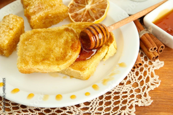 Fototapeta White bread toast with honey on wooden table