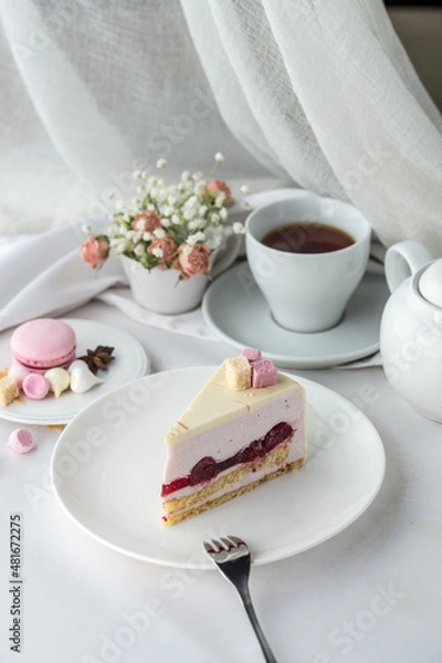 Obraz Delicious cherry mousse cake slice with the layers and cup of tea on the table