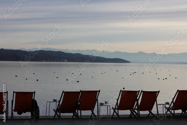 Fototapeta deck chairs in front and the lake starnberg with view on alps