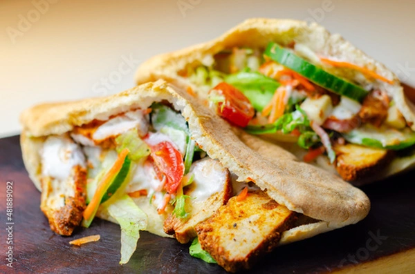 Fototapeta Mediterranean style pitta prepared with spicy chicken, cucumber, tomato, salad and mayo sauce