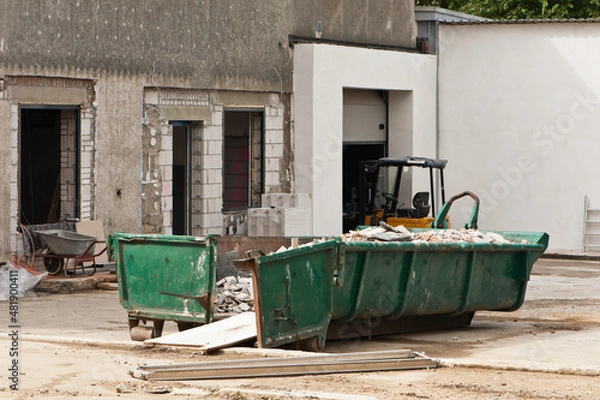 Fototapeta Ein grüner Bauschuttcontainer vor einer Hausbaustelle