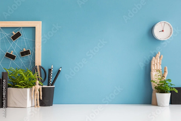 Obraz Home office desk with blue wall and white table mock up.	