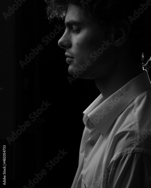 Obraz Caucasian thoughtfull man looking down portrait in white shirt in black and white
