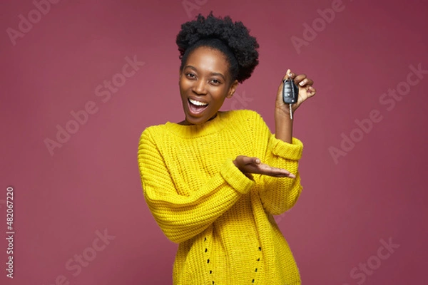 Obraz New car. Young excited successful african american woman hold in hands keys for own automobile, toothy smiling