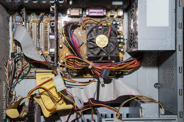 Obraz Old computer inside. Printed circuit boards, wires, connectors, microchips inside the system unit.