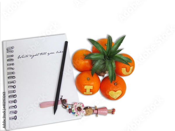 Obraz Pencil and wooden doll on notebook with orange in the form of tree and oranges carved symbol “I Love You” on white background.