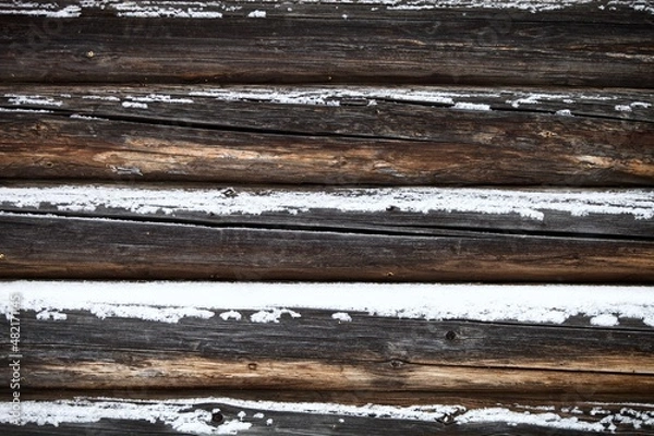 Fototapeta weathered surface of the old wooden log house wall close-up. log walls texture close up. Wooden Log cabin wall in snow close up. The frame of a wooden blockhouse. Vintage log wall surface full frame.