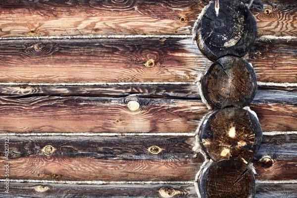 Fototapeta weathered surface of the old wooden log house wall close-up. log walls texture close up. Wooden Log cabin wall in snow close up. The frame of a wooden blockhouse. Vintage log wall surface full frame.