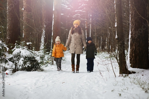 Fototapeta Happy family playing and laughing in winter outdoors in the snow. City park winter day.