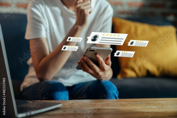 Fototapeta Woman hand holding smartphone and rate your feedback and show five star on application.