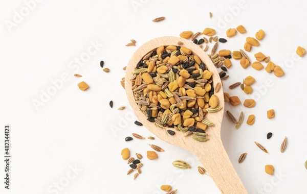 Fototapeta Wooden spoon with Panch phoron  or panchpuran  Indian  five spice seeds  mix  consisting of fenugreek, fennel, cumin, mustard seeds, onion seeds or black cumin in  on white