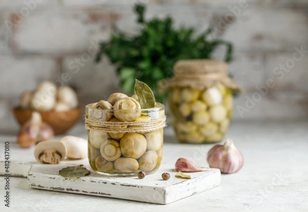Obraz Marinated champignons in a jar. Pickled mushrooms with spices