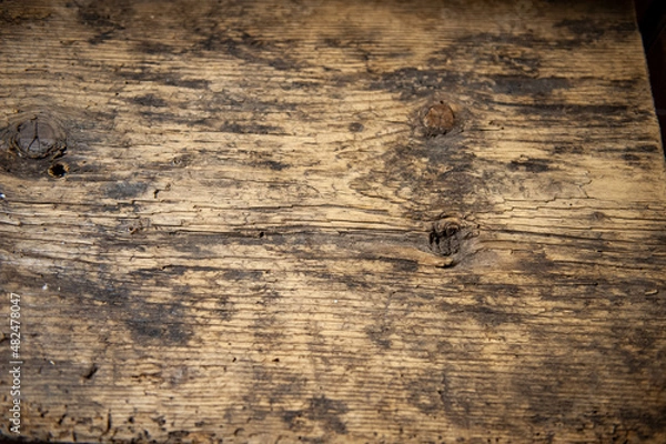 Fototapeta Altholz, verwittert und abgenützt in einem Boden.