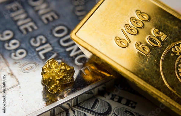 Fototapeta Close-up of a gold ingot on top of a troy ounce silver and coin