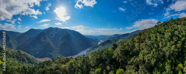 Fototapeta Aerial panorama of amazon rainforest in Tarapoto/Peru with blue sky and river flowing through pristine and untouched landscape