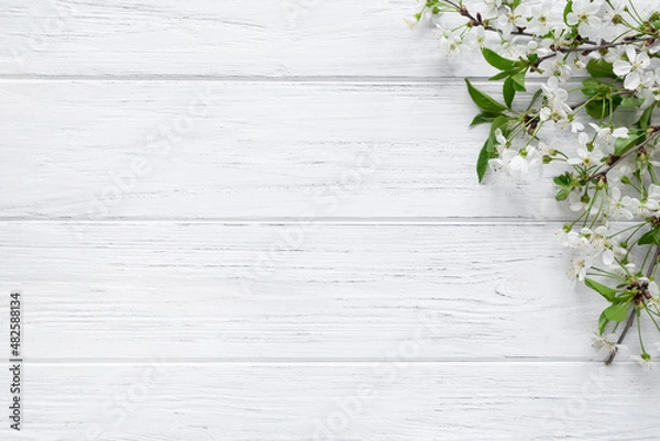 Fototapeta Spring background with blossom cherry flowers on wood table with copy space. Easter banner, flat lay