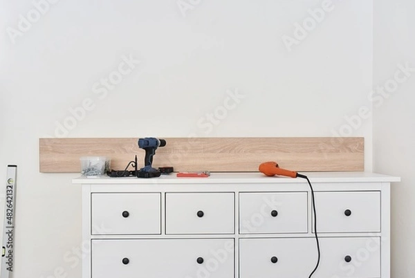 Fototapeta Mounting shelves on the wall. All necessary tools are placed on the chest of drawers