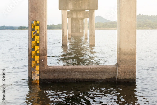 Fototapeta Drought crisis: Water level gauge or staff Gauge at Nong Klang Dong Reservoi, Chonburir. Water meter showing the amount of water in the reservoir. Water level measurement.
