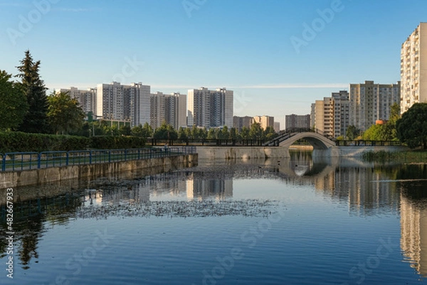 Fototapeta View of the city from the shore of the pond
