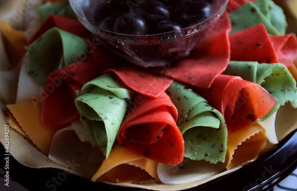 Fototapeta beautiful multicolored cheese plate with dark grapes