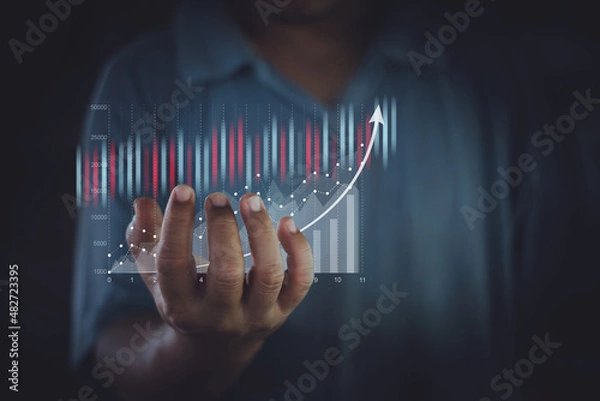 Fototapeta Traders or businessman are showing virtual hologram stocks growing on hand, business growth, progress or success idea concept, strategy planning, stock market, digital assets.
